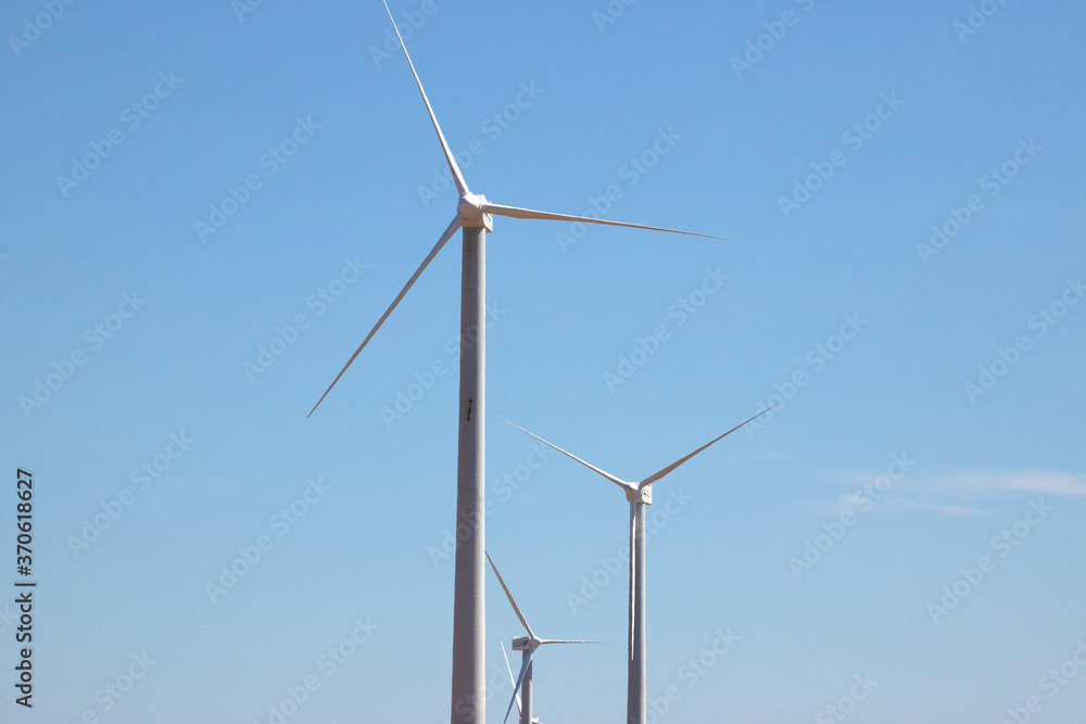 ветряная электWind Generator Turbine in Bright Sun Light on the Clear Blue Sky Background. High quality photo ветряная электWind Generator Turbine in Bright Sun Light on the Clear Blue Sky Background. High quality photo