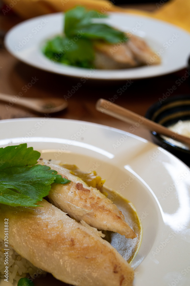 grilled fish fillet on rice with yellow napkin on wooden table
