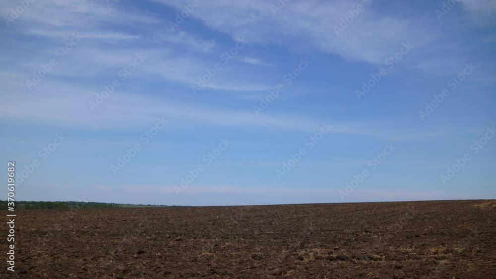 timelapse of plowed field and blue sky, soil and clouds of a bright sunny day - concept of agriculture timelapse of plowed field and blue sky, soil and clouds of a bright sunny day - concept of agriculture