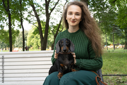 Dachshund dog in the arms of the girl. Portrait