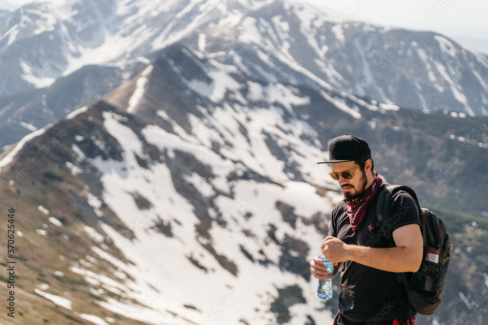  Guy drinking water in the mountains .Hiker drinking water