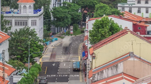 Aerial view of art deco shophouses with red roofs along Neil road in Chinatown area timelapse. Traffic on the street with intersection photo