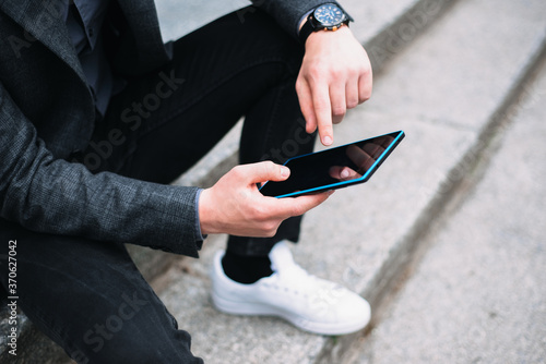 Close up photo of man in casual using tablet outdoor. © Vulp