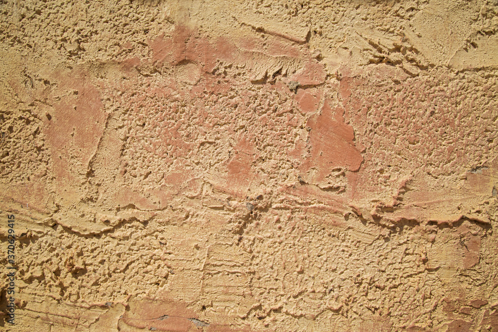 Fototapeta premium photo of an untreated wall in warm colors, cement coating. Texture