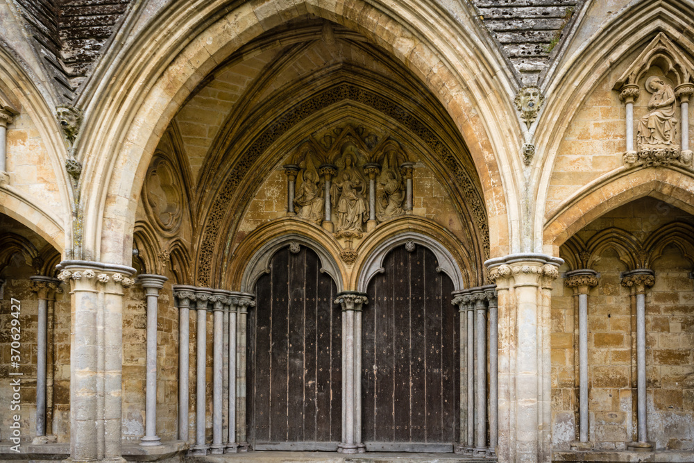 Outside stone arches of Salisbury Cathedral in England, horizontal landscape orientation. 
