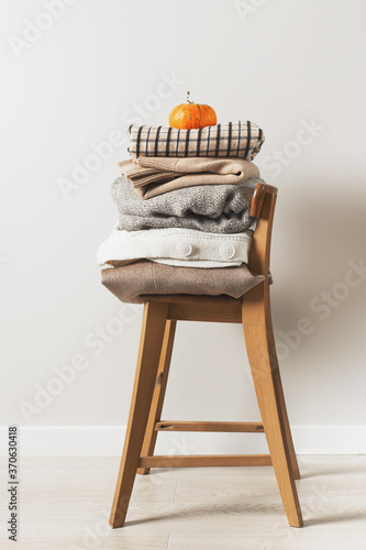 Fotografie Autumn cozy and casual clothes stack close up on chair