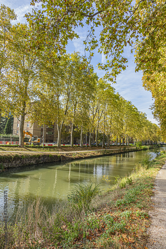 Beautiful autumn views of Canal du Midi (in XVII century - Royal Canal in Languedoc) in Toulouse and trees reflection in water. Toulouse, Haute-Garonne, France. Beautiful autumn views of Canal du Midi (in XVII century - Royal Canal in Languedoc) in Toulouse and trees reflection in water. Toulouse, Haute-Garonne, France.