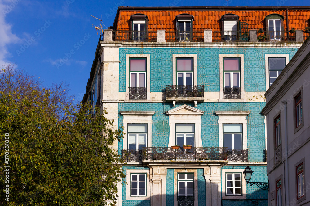 Fototapeta premium Blue tiles front facade of Lisbon building on sunny day. Traditional architecture in Portugal capital. Language translation: Graca street