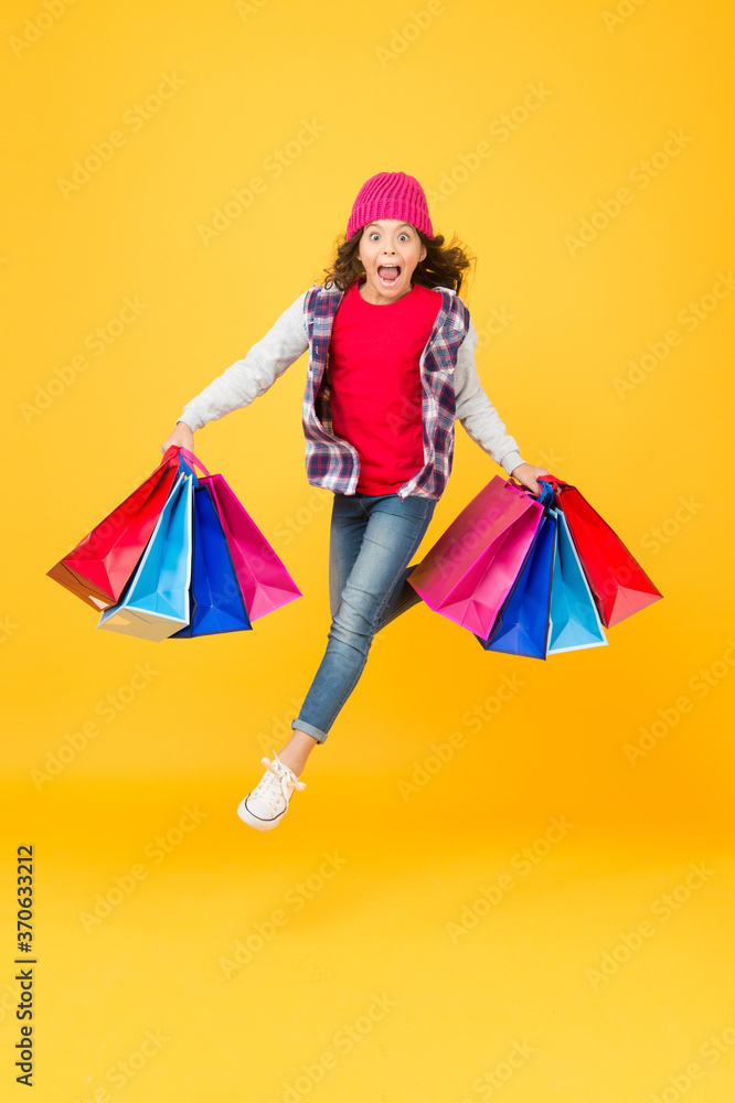 Hurry up, sale ends. Energetic kid carry shopping bags. Emotional shopper haste yellow background. Childrens clothing at sale price. Kids shop. Baby clothes store. Super sale ending soon. Be fast
