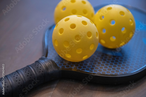 Two pickleballs. Pickleball is a popular American sport played with paddles and whiffleballs on a court 1/4 size of a tennis court.