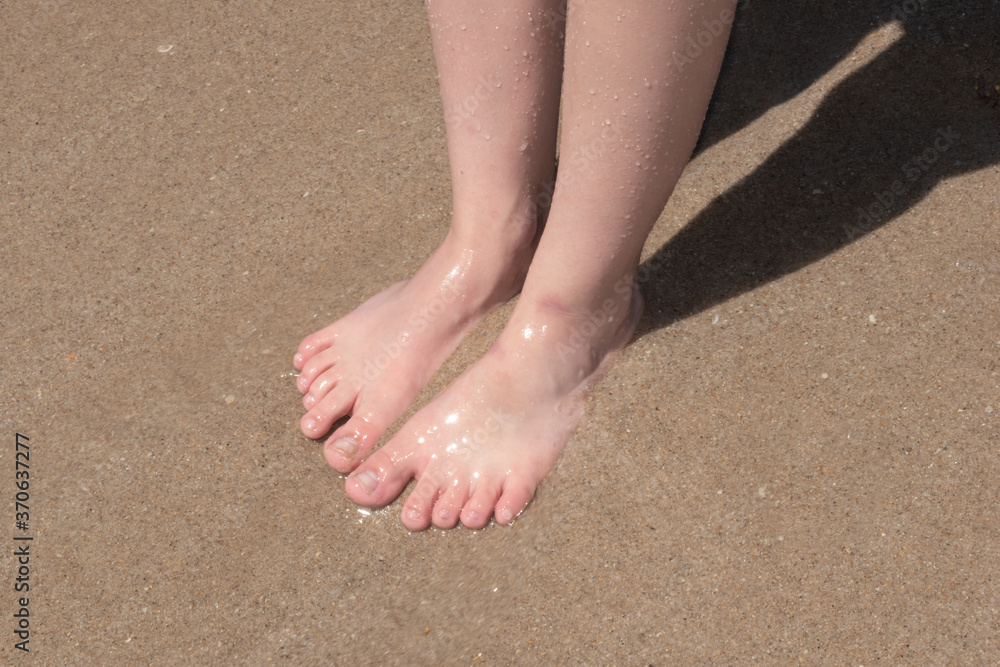 Wet feet on sand at the beach