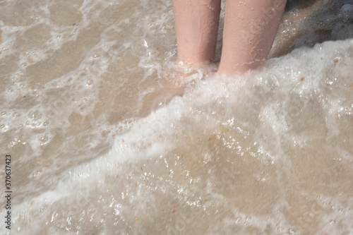 Feet in waves at the beach