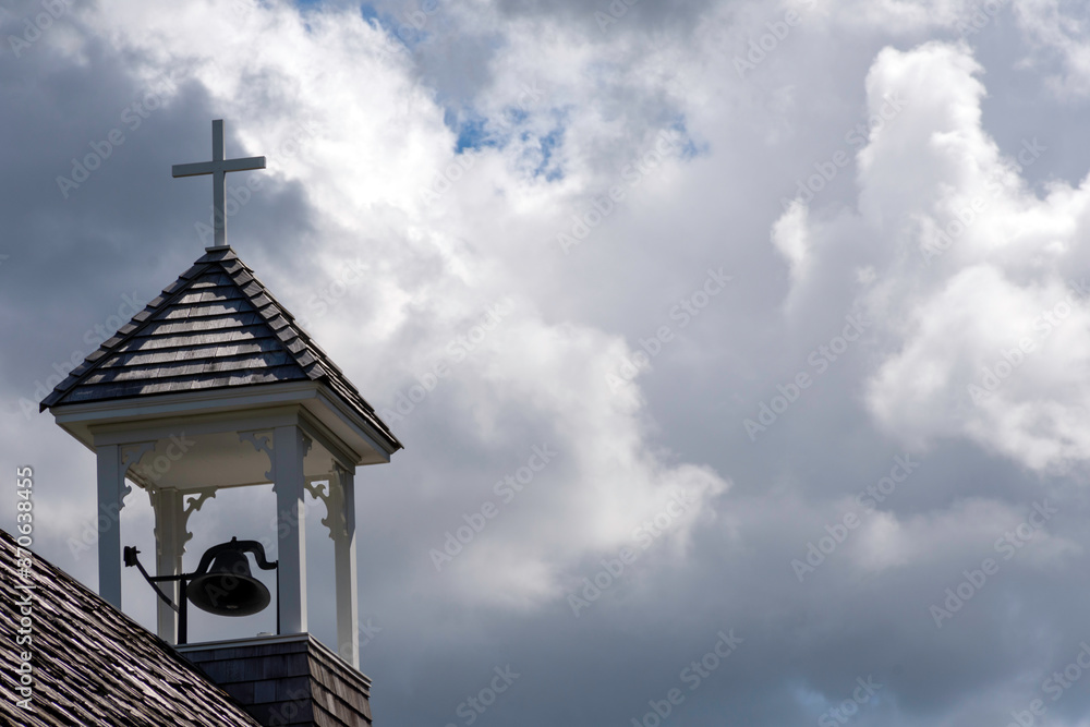 Bell tower of the church with a white cross, symbolizing Christianity and religion. Bell tower of the church with a white cross, symbolizing Christianity and religion.