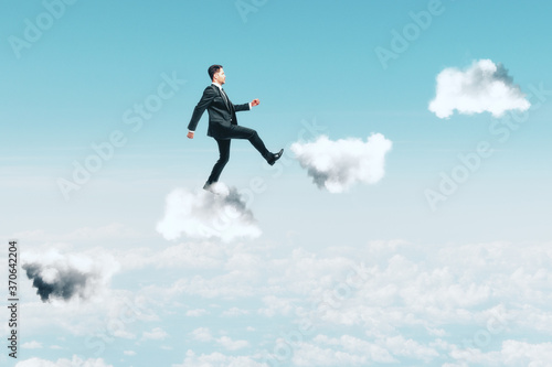 Businessman climbing stairs in the form of clouds.