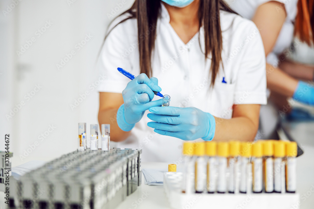 Lab assistant marking test tubes with blood samples. Laboratory interior. Lab assistant marking test tubes with blood samples. Laboratory interior.