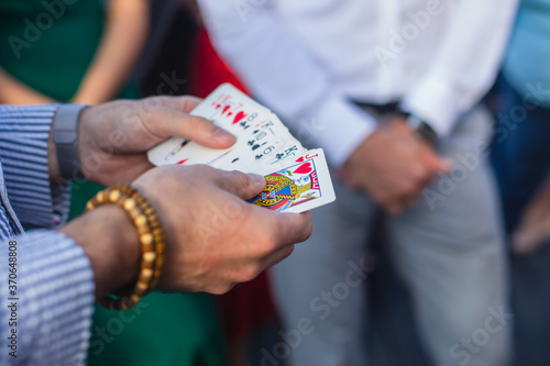 Magician showing card tricks focus in front of guests on party event wedding celebration, juggler performing show