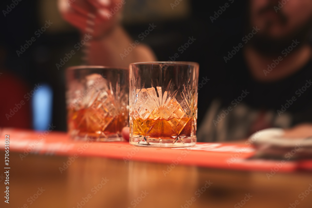 Row line of red colored negroni and spritz aperitif alcohol cocktails on a party of alcohol setting on catering banquet table, vodka, and others on decorated catering table event with bartender Row line of red colored negroni and spritz aperitif alcohol cocktails on a party of alcohol setting on catering banquet table, vodka, and others on decorated catering table event with bartender