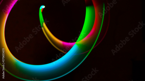 Geometric circles, spirals, circles and arbitrary lines drawn by a multi-colored lamp in the dynamics of movement at a long exposure.