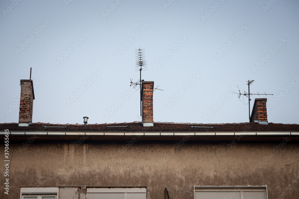Fototapeta premium Television antennas, VHF and UHF frequencies, at the top of a European roof. VHF and UHF are two of the main TV transmission and reception systems.