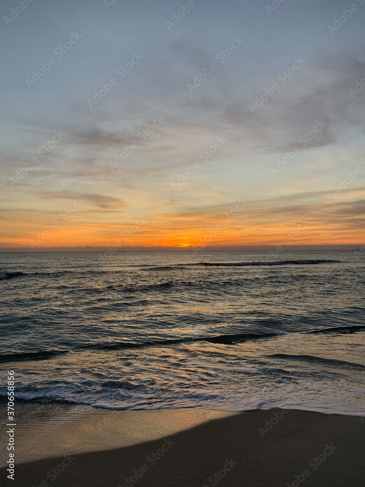 Vibrant sunset over calm beach shoreline