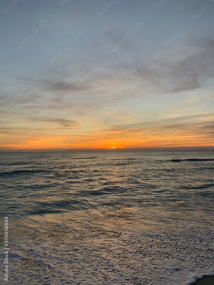 Vibrant sunset over calm beach shoreline