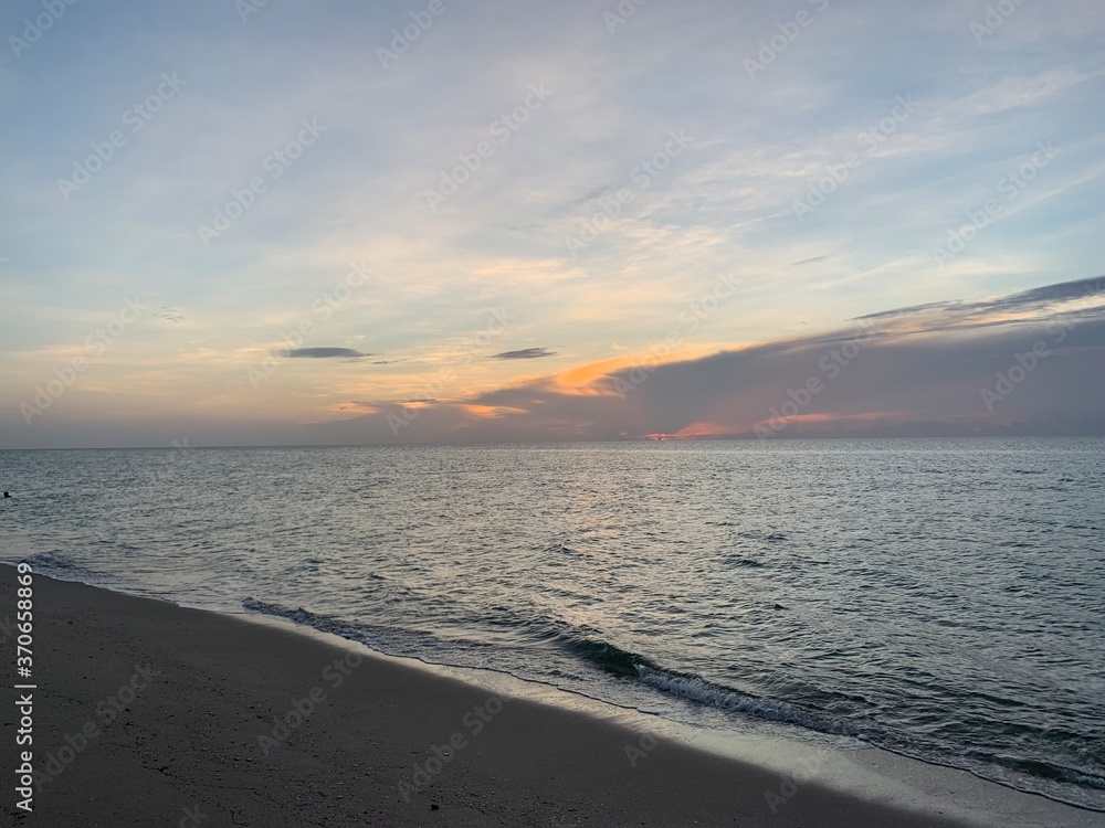 Vibrant sunset over calm sandy beach shoreline