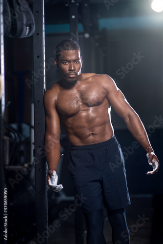 Black male muscular shirtless man with abs and chalk on his hands