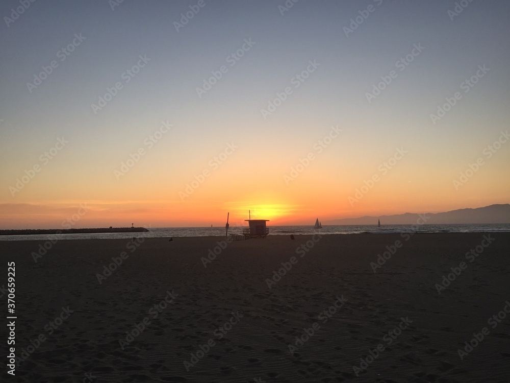 Landscape view of sandy beach sunset with distant coastline at sunset