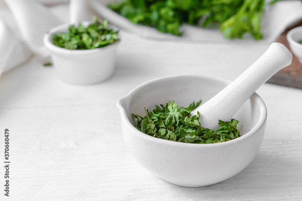 Mortar with dry parsley on table Mortar with dry parsley on table