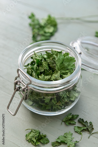 Jar with fresh parsley on table