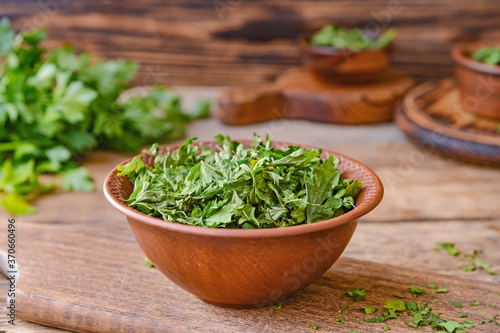 Bowl with dry parsley on table