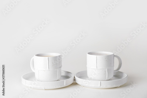 Cups of hot coffee on white background