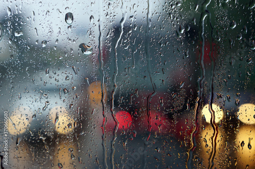 Fototapeta Naklejka Na Ścianę i Meble -  Bokeh in the rain. Water drops on the glass against a bokeh light background
