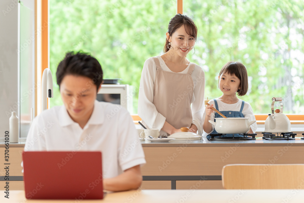 キッチンで働くお父さんと見守る親子 キッチンで働くお父さんと見守る親子