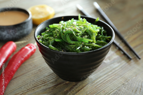 Bowl with tasty seaweed salad on table