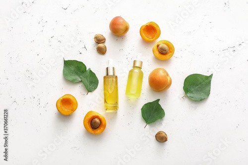 Bottles of apricot essential oil on white background