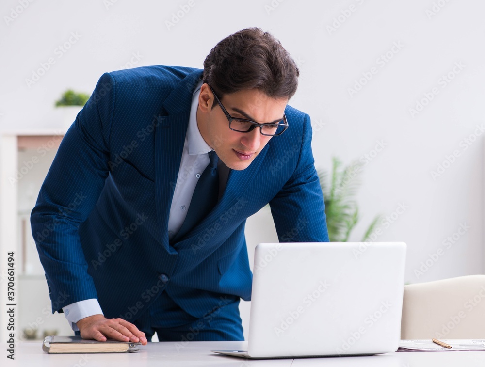 Young handsome businessman employee working in office at desk Young handsome businessman employee working in office at desk