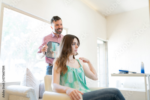 Woman Looking At Haircut Done By Hairdresser