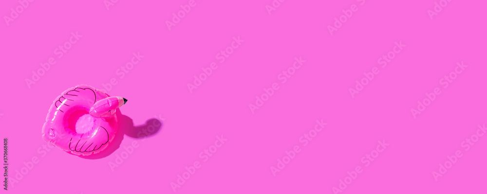 Summer concept with a pink flamingo float - flat lay Summer concept with a pink flamingo float - flat lay