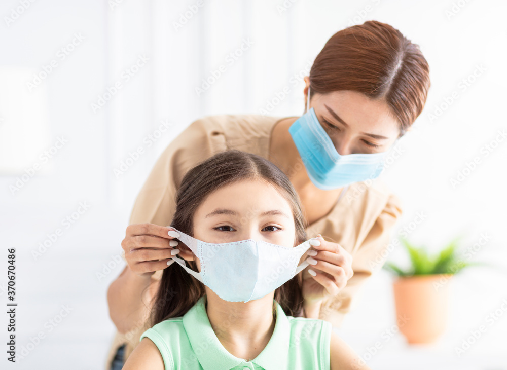 mother help her daughter wearing healthy face mask
