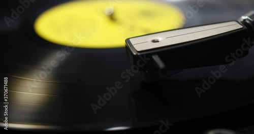 Record player needle lowering and then moving across the record photo