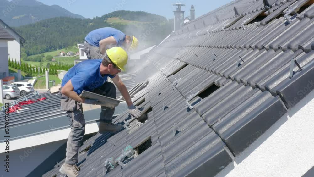Technician installing solar panels system on house rooftop in Slovenia Technician installing solar panels system on house rooftop in Slovenia