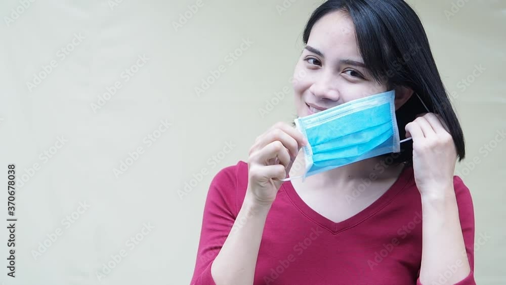 woman demonstrate how to gloves protective mask for corona virus prevention, standing on white background copy-space. waring mask footage. woman demonstrate how to gloves protective mask for corona virus prevention, standing on white background copy-space. waring mask footage.