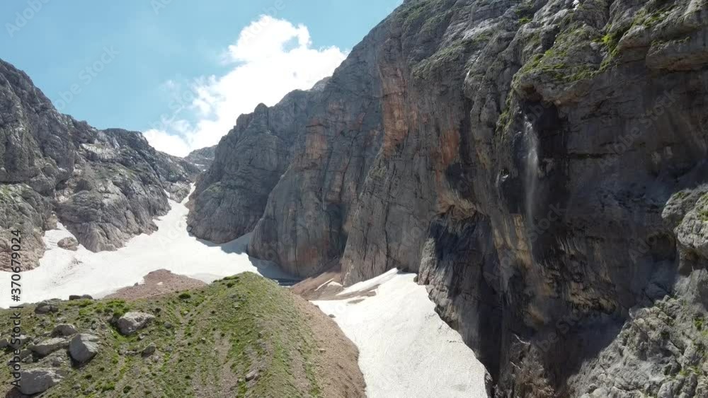 Waterfall in the mountains. The wind blows off jets of water. Aerial photography