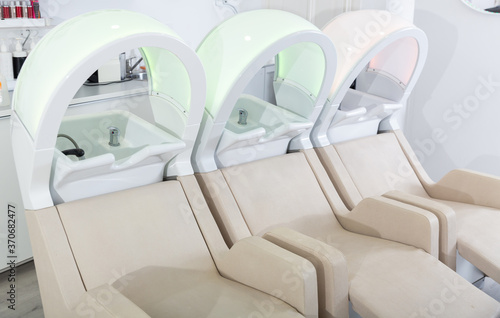 Empty massaging chairs for washing hair in european beauty salon