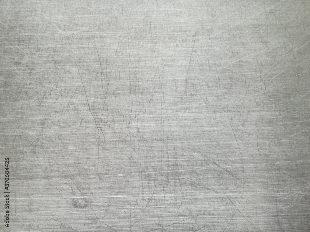 The stainless steel surface is scratched from the use as a background,metal brushed texture. The stainless steel surface is scratched from the use as a background,metal brushed texture.