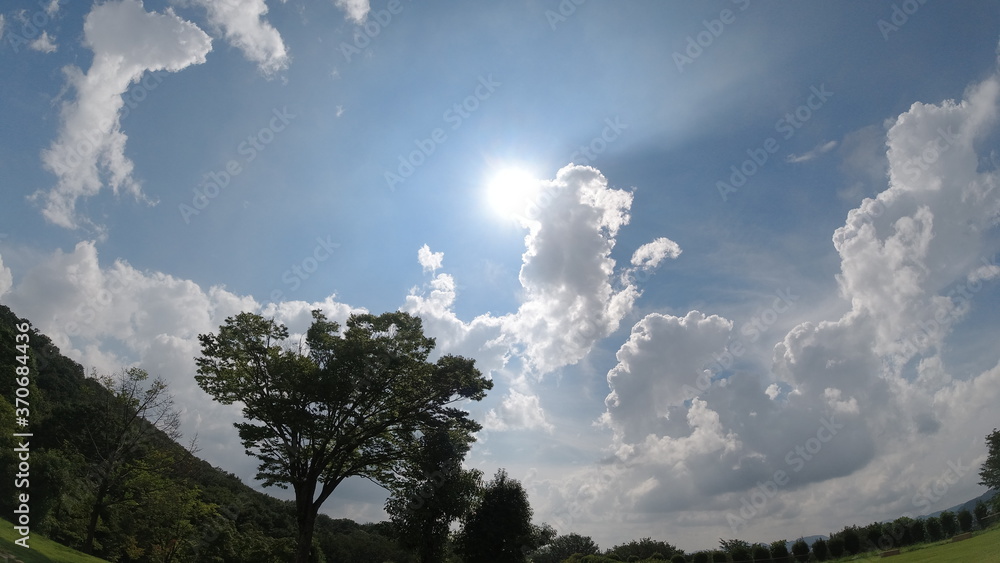 ギラギラした夏の太陽と青い空と雲 ギラギラした夏の太陽と青い空と雲