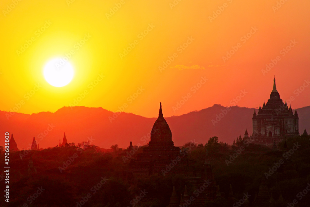 Silhouettes of ancient Buddhist pagodas on the background of sunset sky in Old Bagan, Myanmar