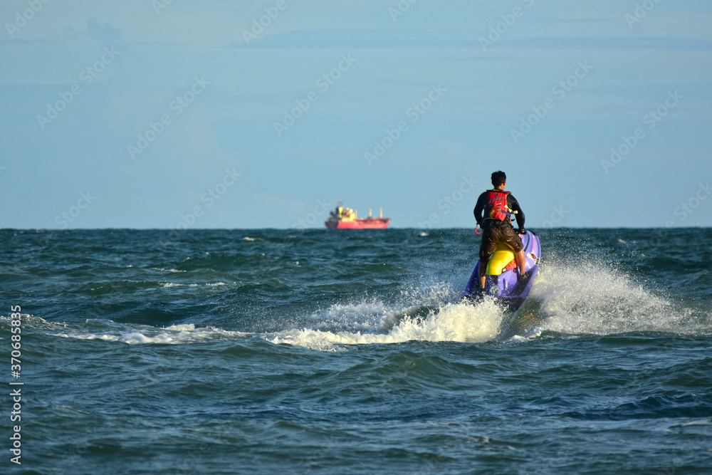 A man riding a water scooter Summer vacation in the tropical sea The hobby of a young man riding the sea Water sport scooter activities A man riding a water scooter Summer vacation in the tropical sea The hobby of a young man riding the sea Water sport scooter activities