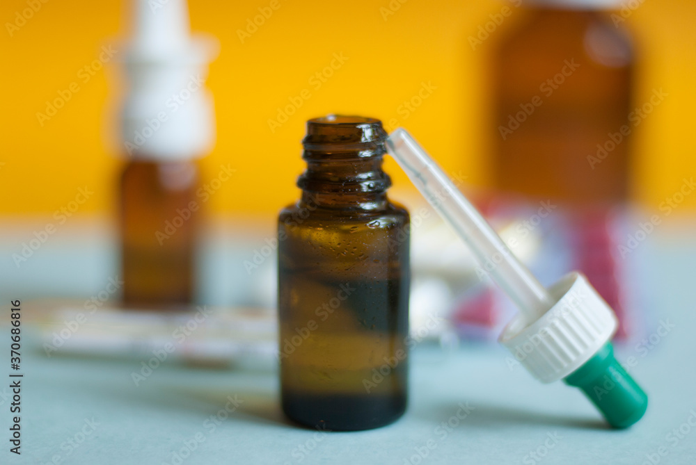 Medicines for colds, flu, viral diseases. Cough and cold remedies. Glass jars with syrup, colored tablets. Medicines for colds, flu, viral diseases. Cough and cold remedies. Glass jars with syrup, colored tablets.